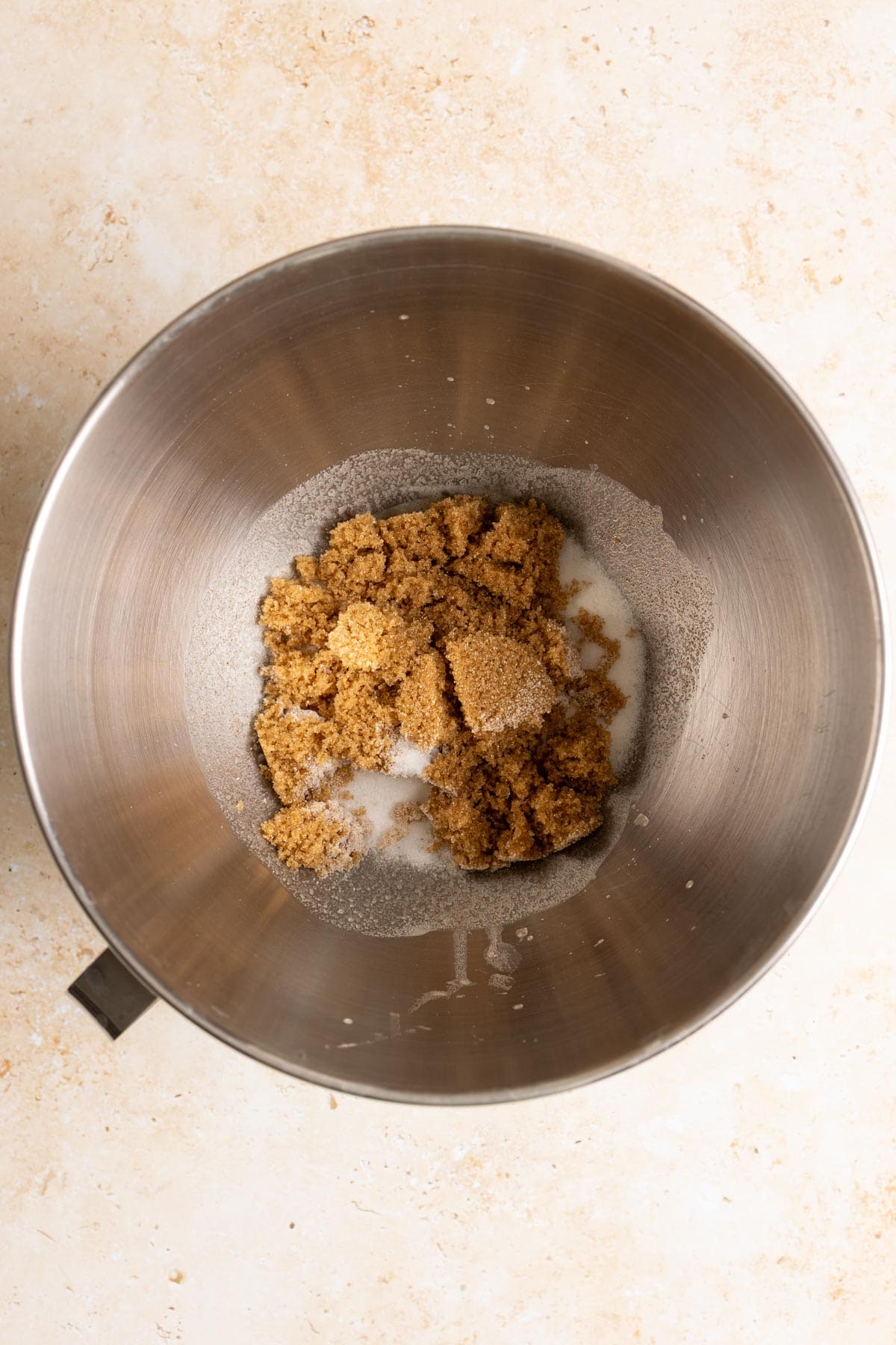 Brown butter and sugar in a metal mixing bowl.