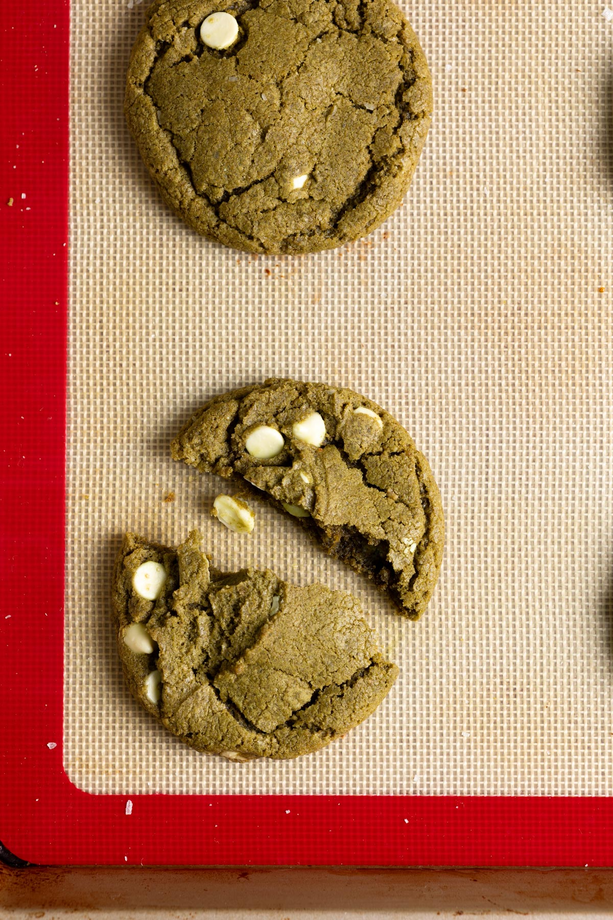 A sourdough discard matcha cookie broken in half.