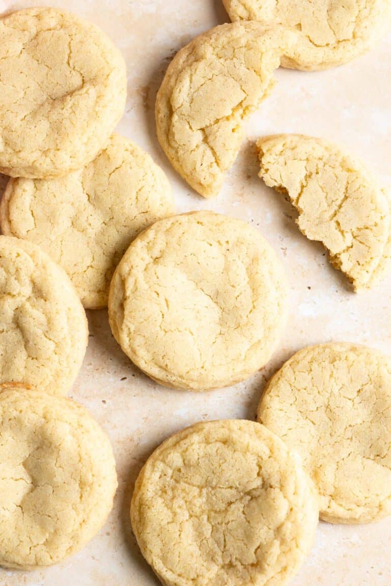 Sourdough sugar cookies spread out on a marble surface.