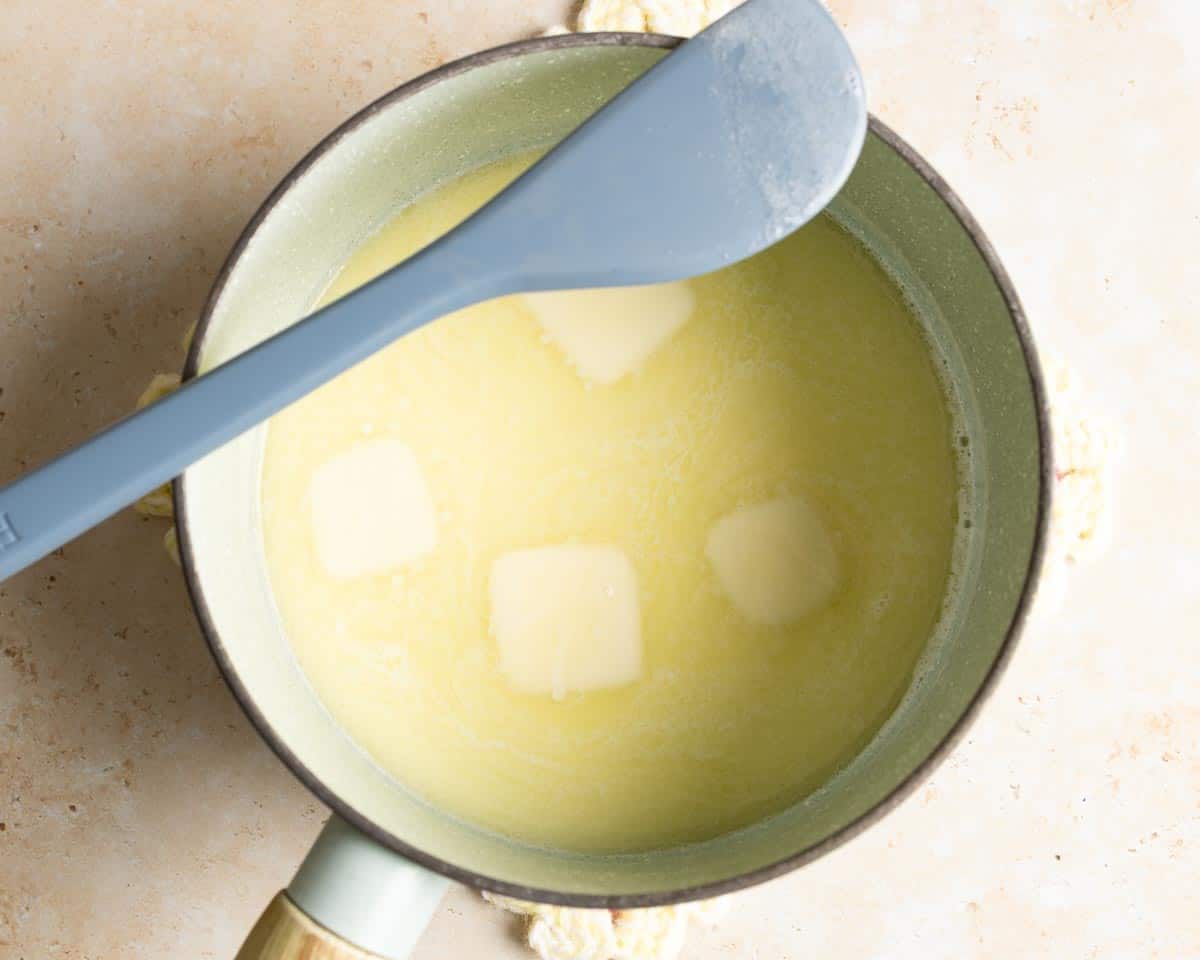 Scald milk with melted butter in a saucepan.