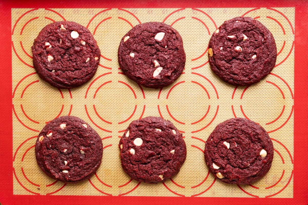 6 baked sourdough red velvet cookies on a baking sheet.
