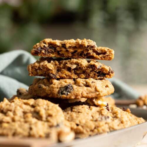 2 half pieces of sourdough oatmeal raisin cookies stacked on top a full cookie, showing their interior texture.