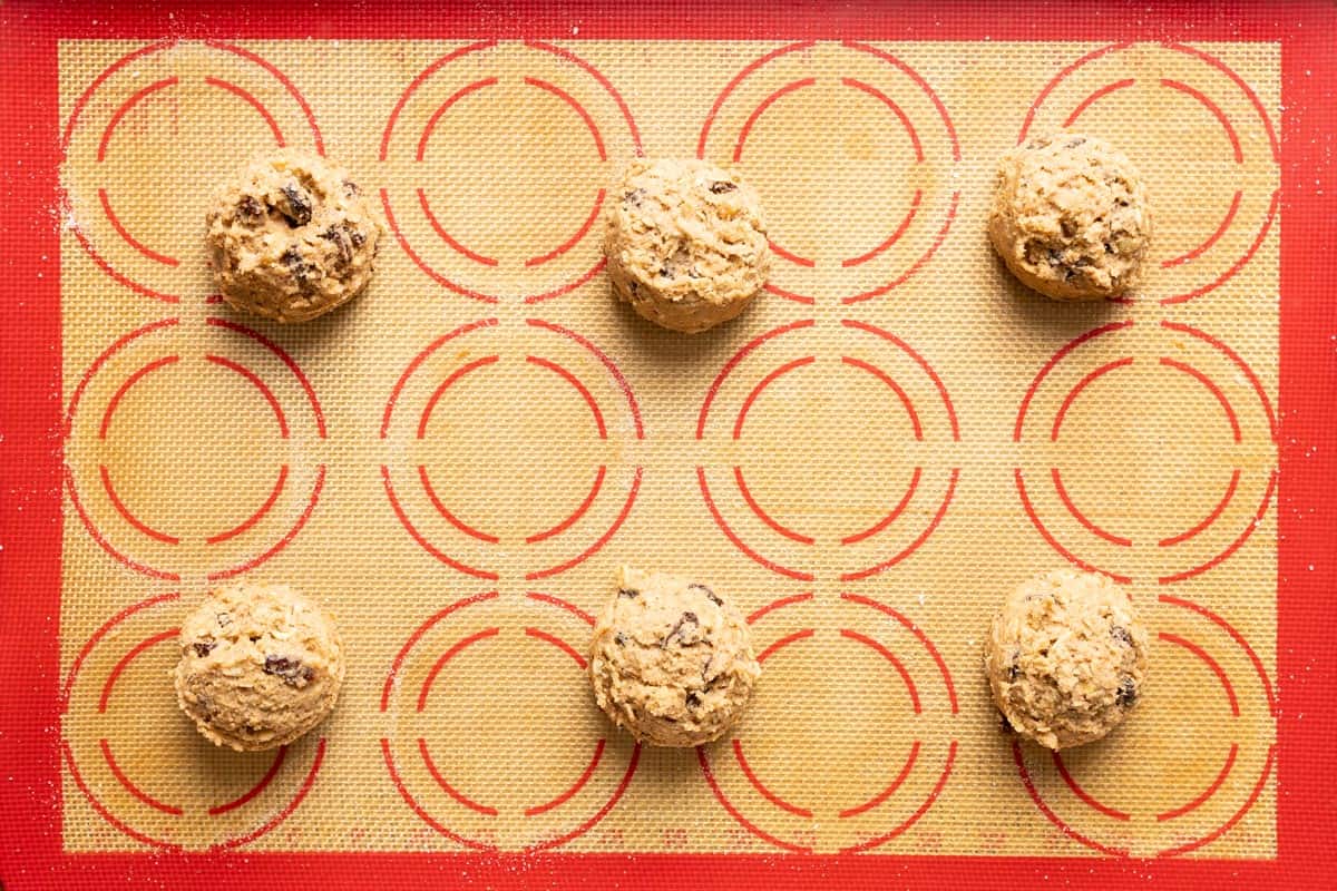 6 sourdough oatmeal raisin cookie dough balls on a baking sheet.