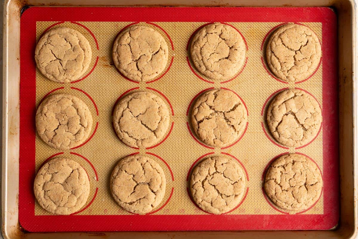 A dozen baked sourdough discard snickerdoodle cookies on a baking sheet.