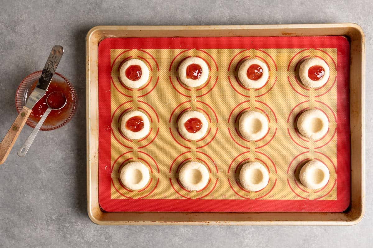 Fill thumbprint cookie dough with jam.