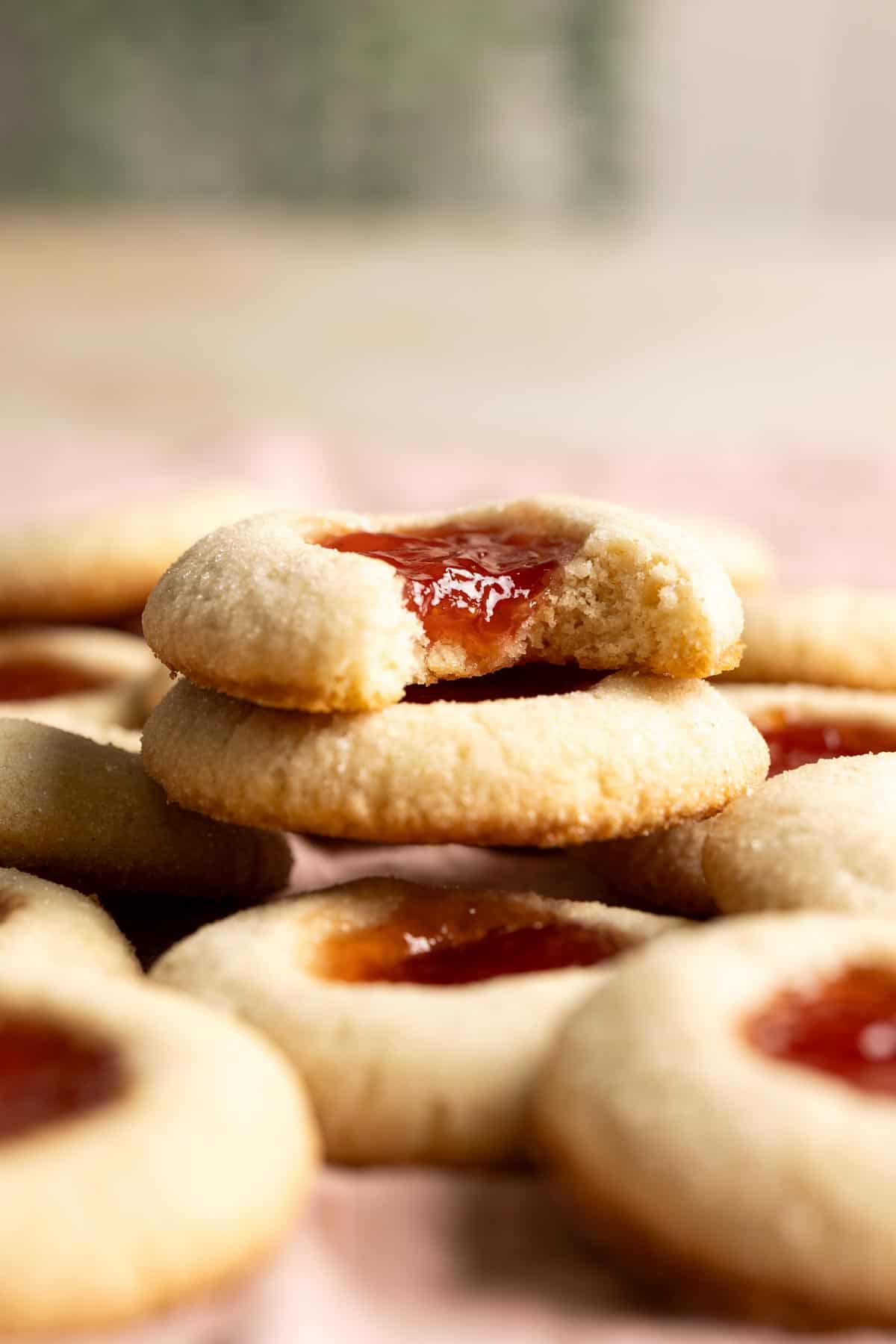 A stack of two sourdough discard thumbprint cookies, the top one is half eaten.
