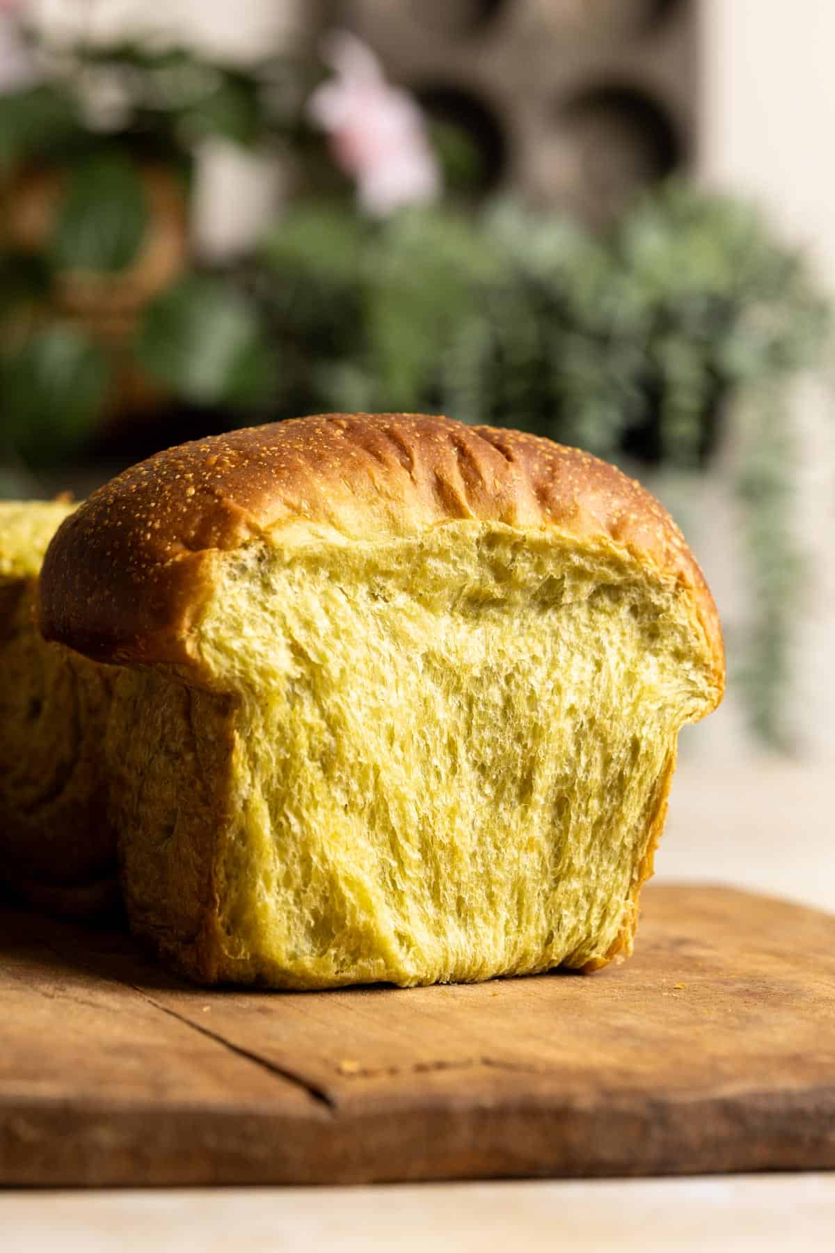 A section of sourdough matcha milk bread on a wooden board.