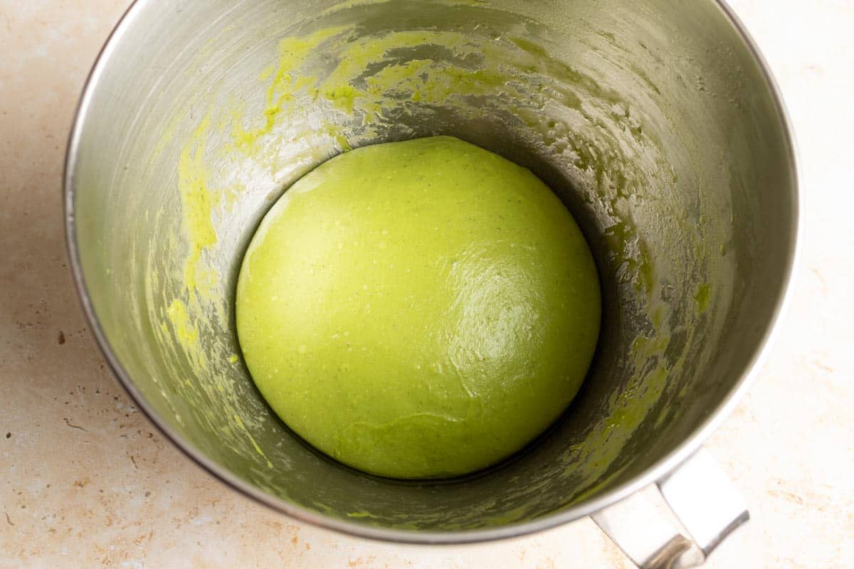 Matcha sourdough milk bread dough ball in a mixing bowl.