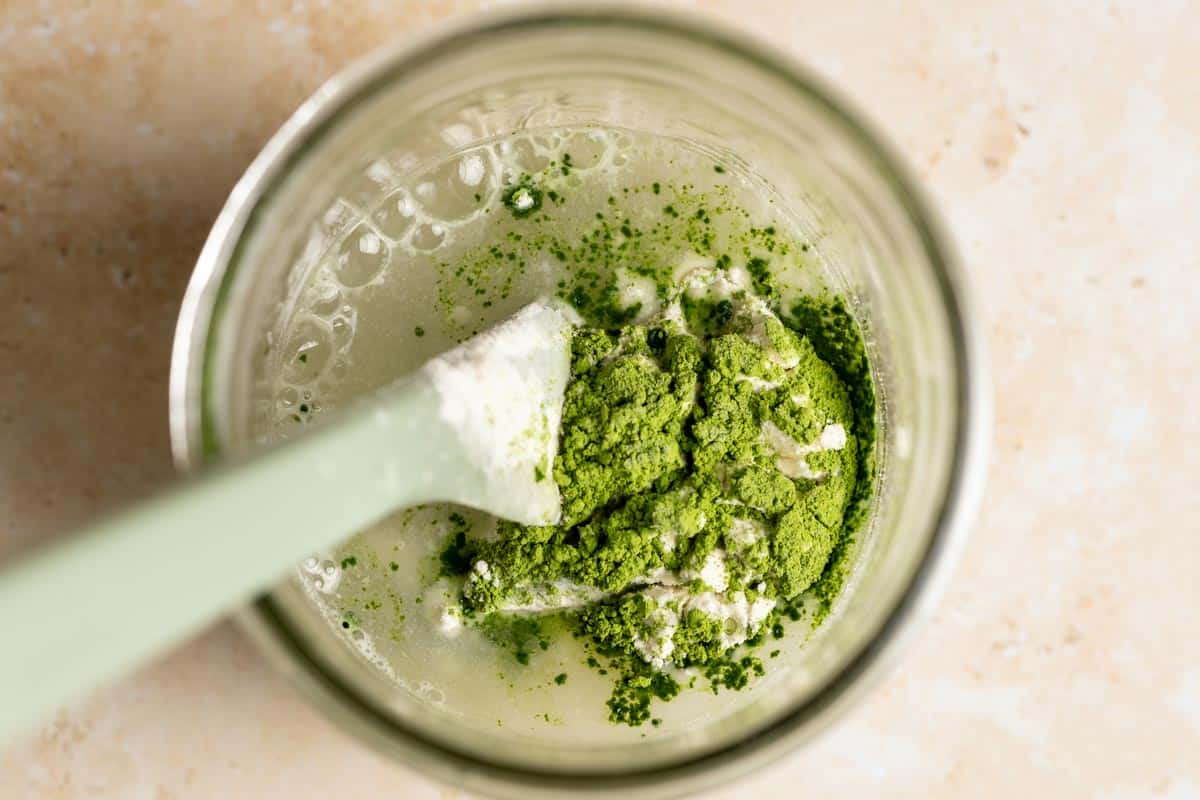 Ingredients for matcha starter in a jar with a spatula.