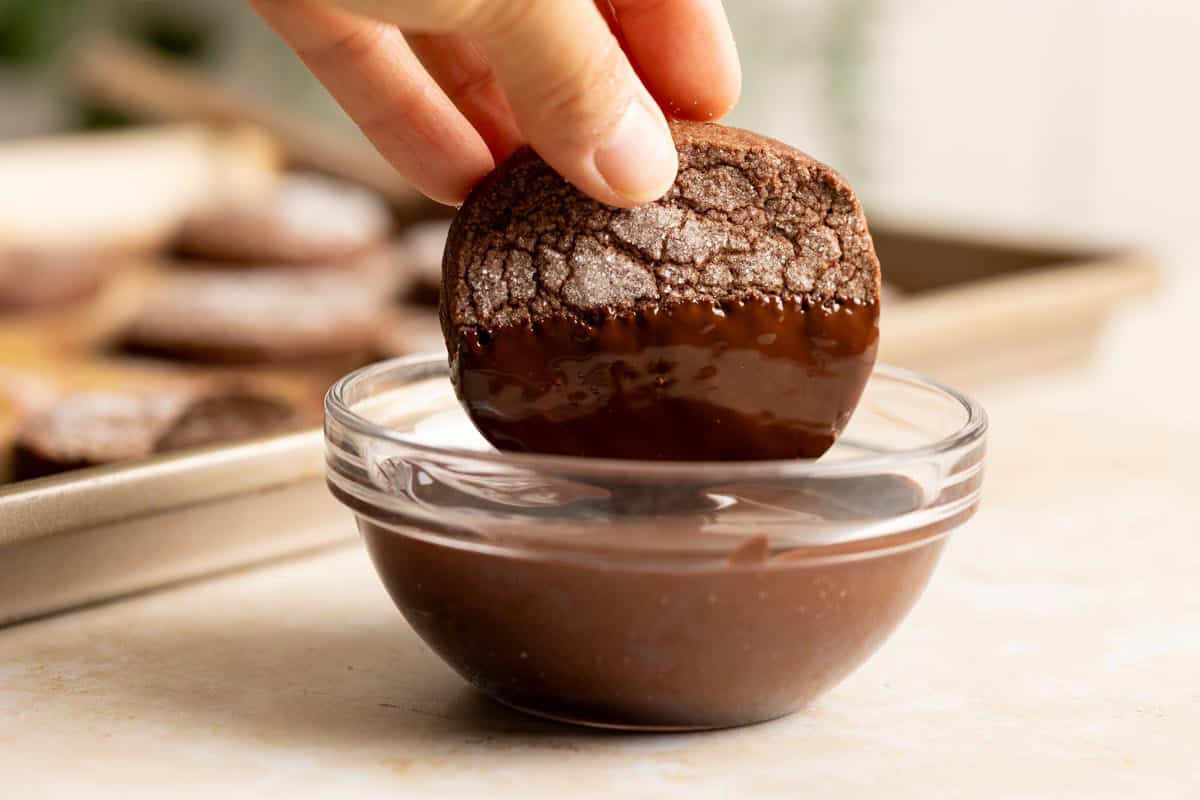 Dipping a sourdough chocolate shortbread cookie in melted chocolate.