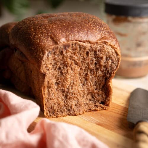 A loaf section of chocolate sourdough milk bread on a cutting board.