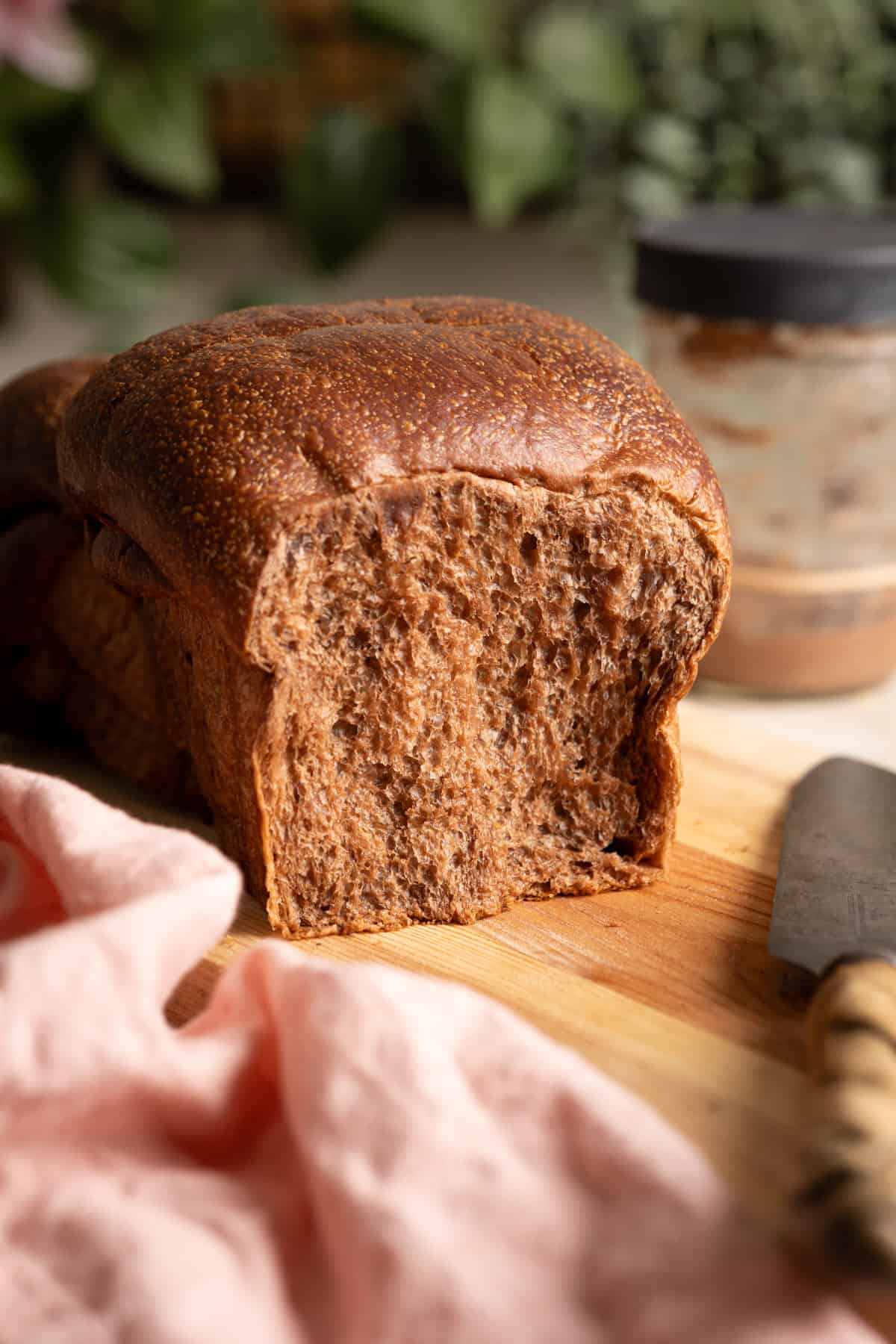 A loaf section of chocolate sourdough milk bread on a cutting board.