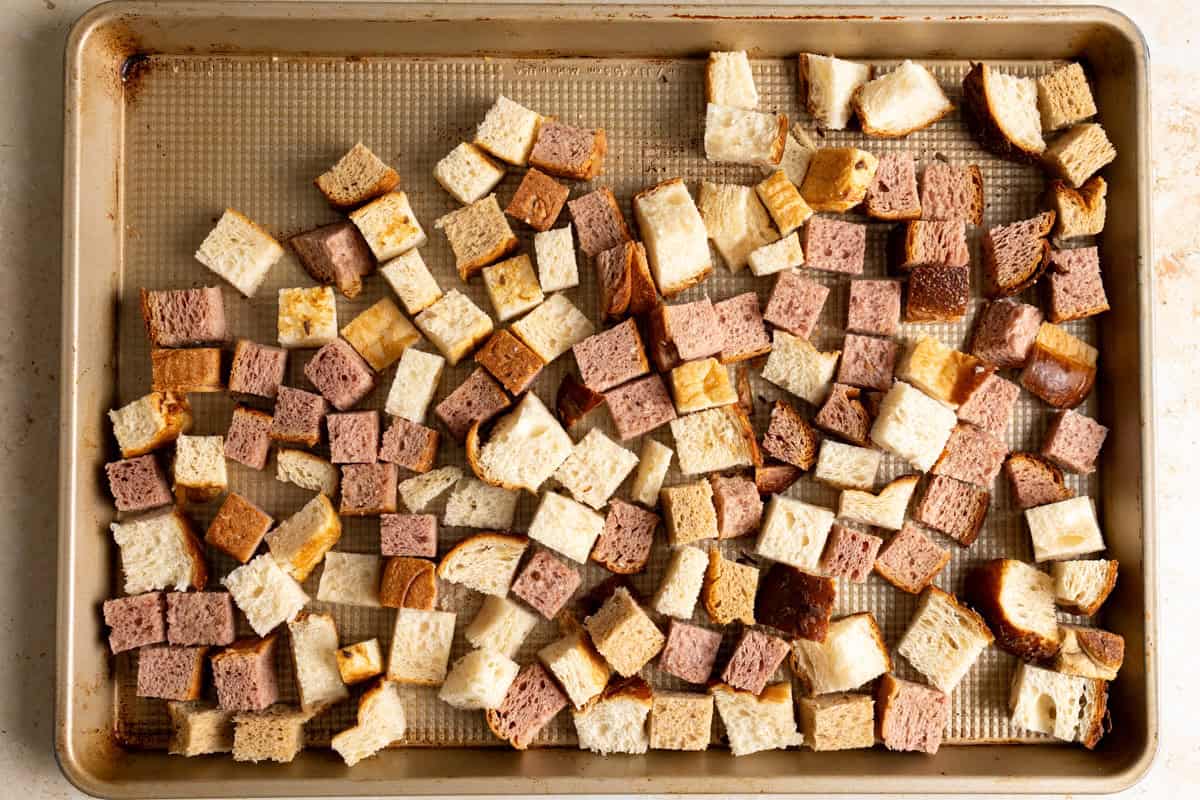 Dry bread cubes on a baking tray.