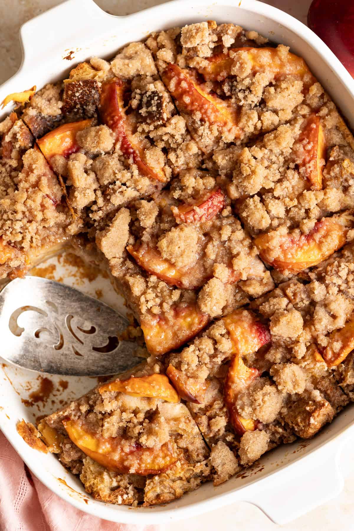 Peach cobbler bread pudding in a baking pan, 1 slice is missing.