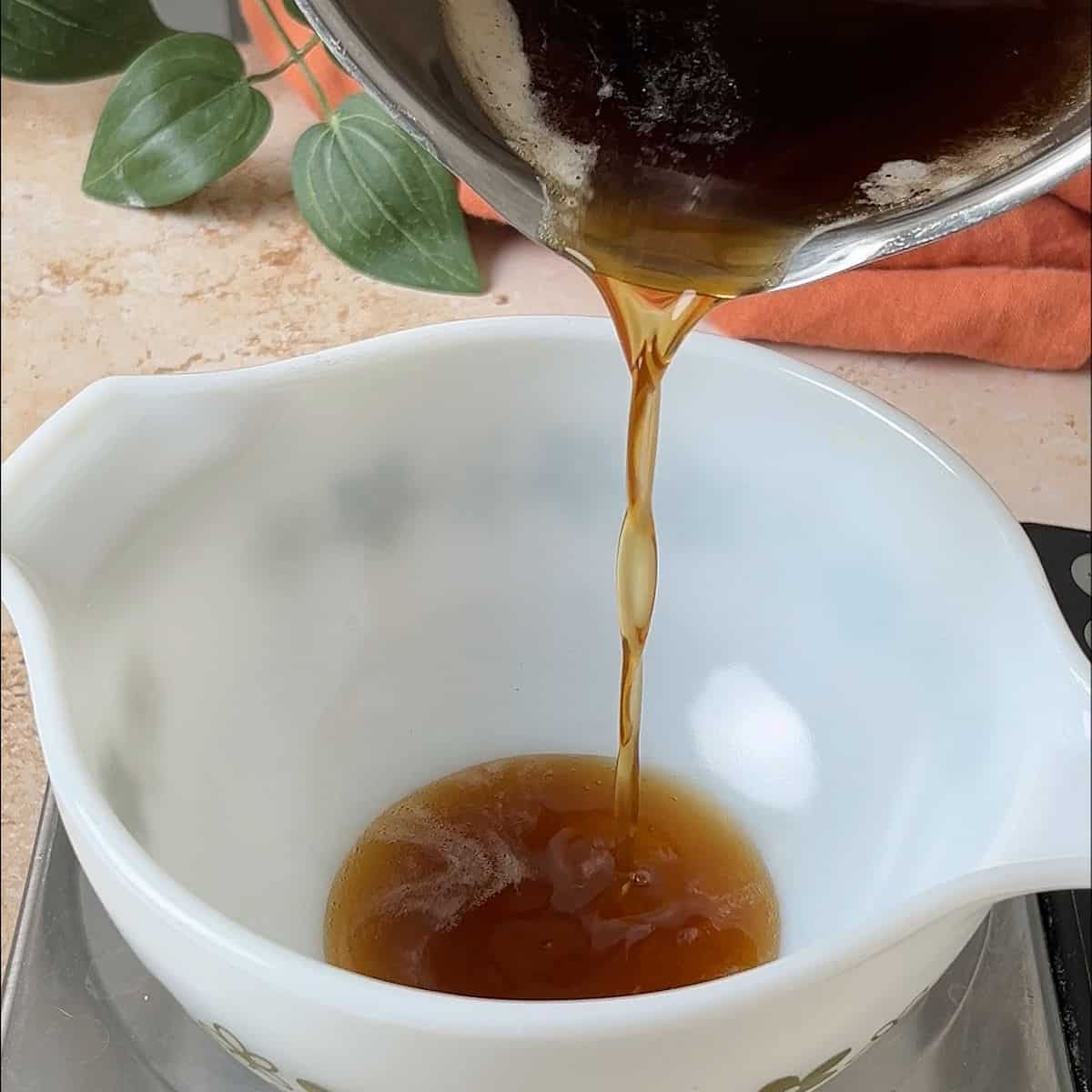 Pouring brown butter into a small mixing bowl.