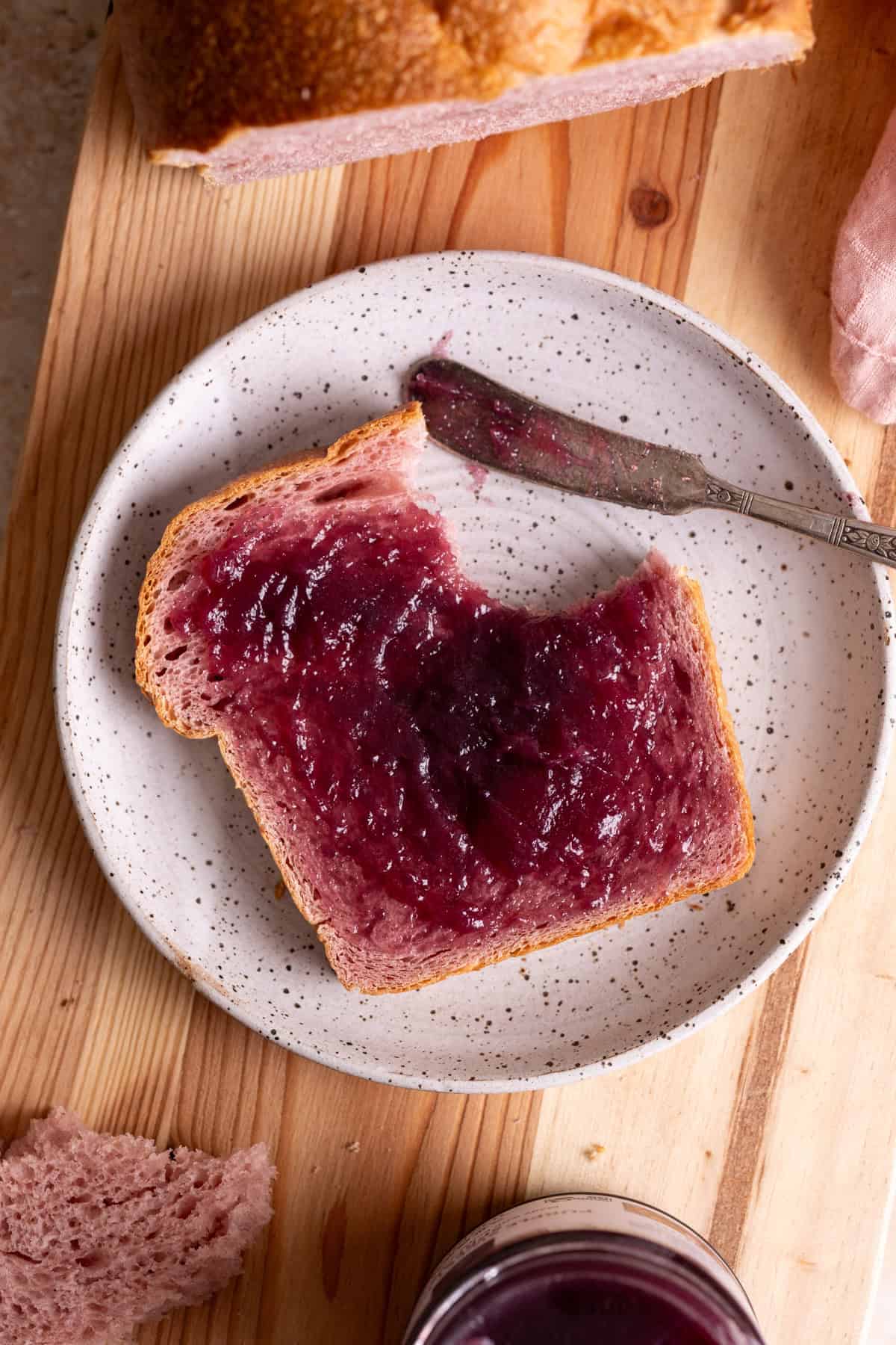 A slice of purple sweet potato milk bread with purple sweet potato spread on top.