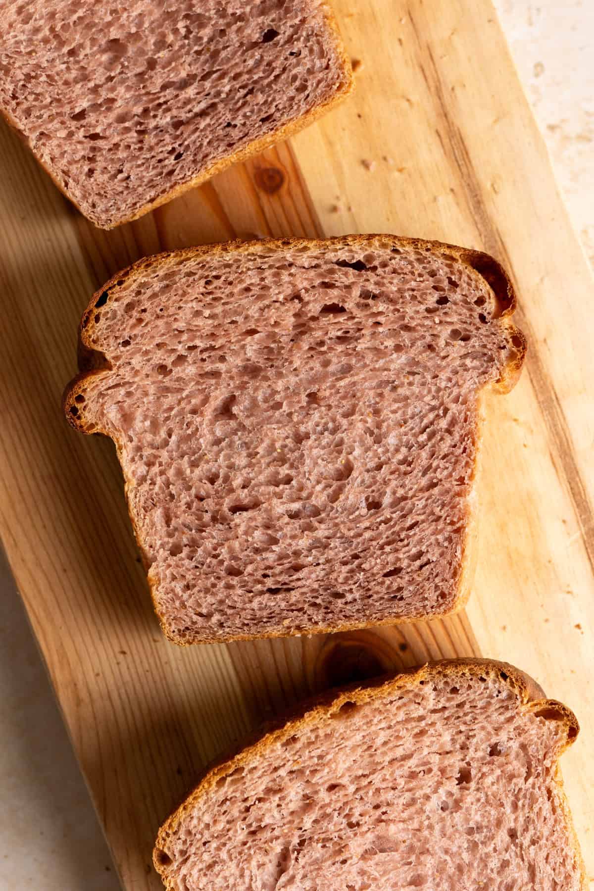 3 slices of sourdough strawberry milk bread on a cutting board.