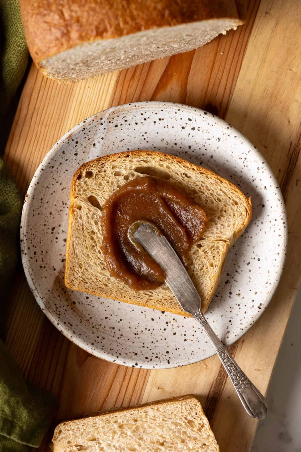 A slice of apple bread with apple butter spread on top.